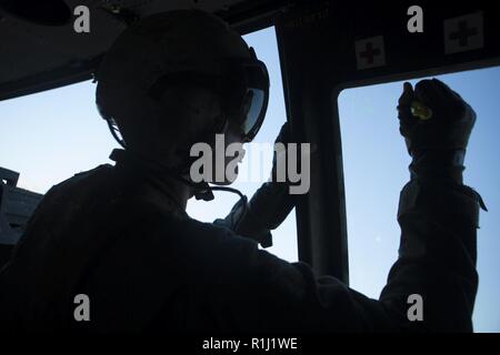 U.S. Marine Corps Cpl. Preston Eisele, a UH-1Y aircraft crew chief with Marine Light Attack Helicopter Squadron (HMLA) 469, Marine Aircraft Group 38, 3rd Marine Aircraft Wing, prepares to shoot during a close air support exercise in support of Weapons and Tactics Instructor (WTI) course  1-19 in Yuma, Arizona, Sept. 20, 2018. WTI is a seven-week training event hosted by Marine Aviation Weapons and Tactics Squadron (MAWTS-1) which emphasizes operational integration of the six functions of Marine Corps aviation in support of a Marine air-ground task force. WTI also provides standardized advanced Stock Photo