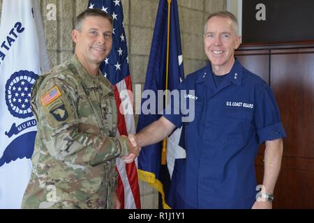 HONOLULU, Hawaii – (Sept. 25, 2018) Pacific Ocean Division (POD) Commanding General, Brig. Gen. Thomas Tickner (left), gives an official POD coin to Rear Adm. Kevin Lunday (right), Commander, 14th Coast Guard District, following an office call to discuss shared strategic areas of interest, as well as to identify future partnership opportunities between the two organizations, who also share a similar area of responsibility within the Indo-Pacific region. POD provides sustainable and resilient engineering solutions to the U.S. Coast Guard, in addition to numerous other entities, in collaboration Stock Photo