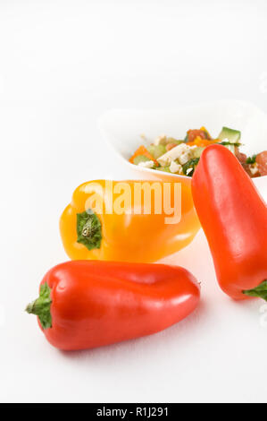 Red, Yellow Peppers and Healthy Salad with Feta Cheese on white Background Stock Photo