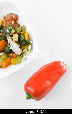 Red, Yellow Peppers and Healthy Salad with Feta Cheese on white Background Stock Photo