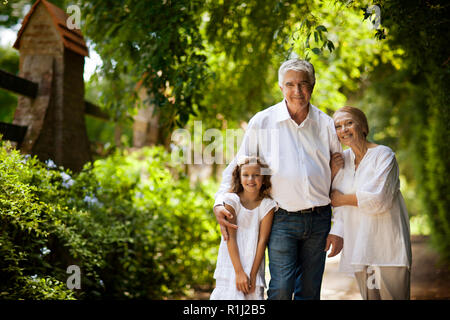 Portrait of young girl and her grandparents on country road. Stock Photo