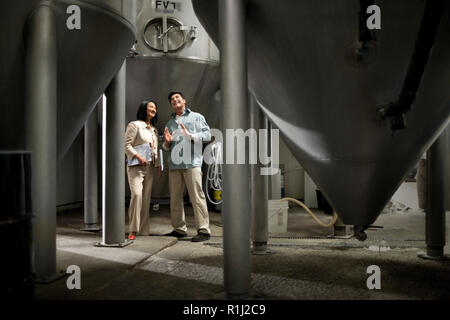 Two colleagues discussing work in a warehouse. Stock Photo