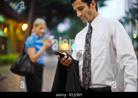 Businessman and businesswoman using their cellphones. Stock Photo