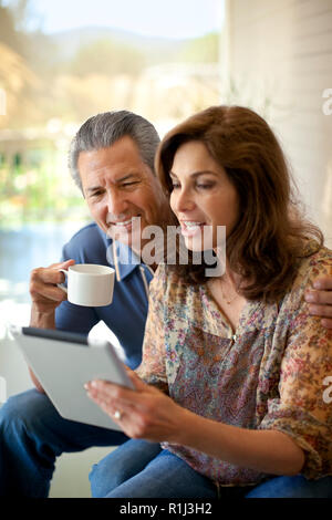 Couple looking at an ipad on their verandah. Stock Photo
