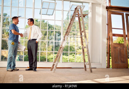 Mid adult builder working on blue prints. Stock Photo