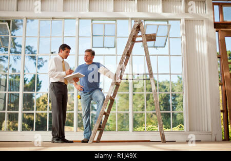 Two businessmen looking at samples on a construction site. Stock Photo