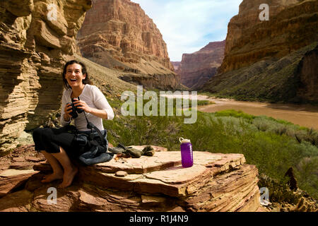 Smiling young woman sight seeing in a canyon. Stock Photo