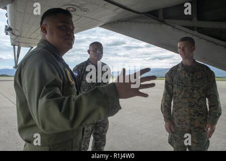 U.S. Marines Staff Sgt. Jose Martinez, a helicopter crew chief with Special Purpose Marine Air-Ground Task Force – Southern Command, gives Honduran Navy Lt. Milton Roldan Meza Sanchez, SPMAGTF-SC’s newly appointed Honduran liaison officer, a tour of the flight line here, September 26. Meza’s appointment as LNO and assistant operations officer marks the third occasion SPMAGTF-SC has integrated a partner nation’s military officers into its formation. The Marines and Sailors of SPMAGTF-SC are conducting security cooperation training and engineering projects alongside partner nation military force Stock Photo