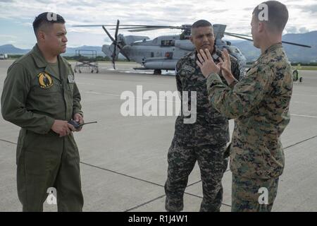 U.S. Marines Staff Sgt. Jose Martinez, a helicopter crew chief with Special Purpose Marine Air-Ground Task Force – Southern Command, gives Honduran Navy Lt. Milton Roldan Meza Sanchez, SPMAGTF-SC’s newly appointed Honduran liaison officer, a tour of the flight line here, September 26. Meza’s appointment as LNO and assistant operations officer marks the third occasion SPMAGTF-SC has integrated a partner nation’s military officers into its formation. The Marines and Sailors of SPMAGTF-SC are conducting security cooperation training and engineering projects alongside partner nation military force Stock Photo