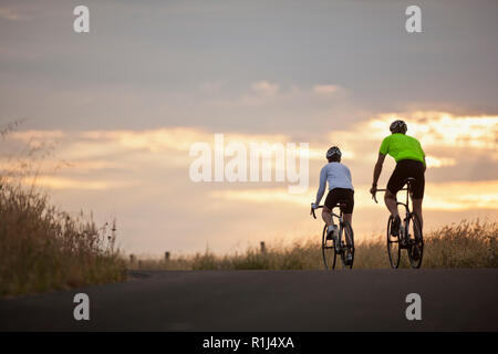 Mature couple cycling along a country road. Stock Photo