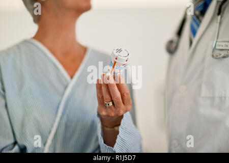 Mature woman chats with her doctor about the bottle of pills she has been given. Stock Photo