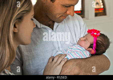 New parents cradle their newborn baby girl. Stock Photo