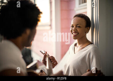 Young man playing guitar for his smiling partner. Stock Photo