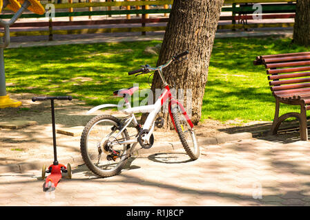 Bicycle and scooter for kids in the park Stock Photo