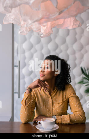 Dark-haired woman feeling thoughtful while waiting for husband Stock Photo