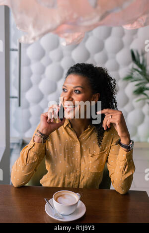 Dark-eyed woman calling her best friend inviting her for dinner Stock Photo