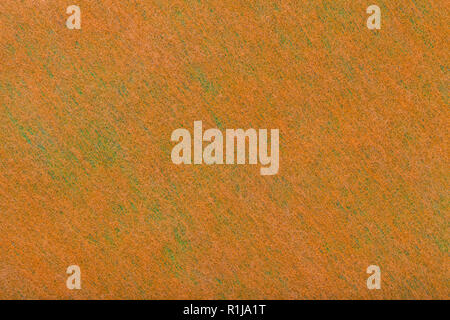 Construction of a bright orange background with light green spots of felt fabric, closeup. Texture of woolen matt textile. Cloth backdrop. Stock Photo