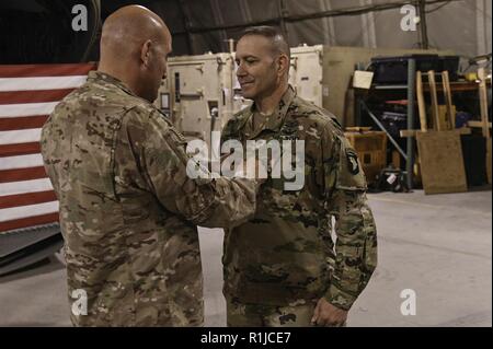 U.S. Army Maj. Gen. Andrew Poppas, the Resolute Support deputy chief of staff for operations and the 101st Airborne Division (Air Assault) commander pins the rank of Colonel on Chris Miletello at Bagram Airfield, Afghanistan Oct 6. Miletello, a Baton Rouge native serves as the Deputy Commanding Officer for Task Force Destiny. His military career of 33 years has taken him from being an enlisted service member as a military policeman, a warrant officer piloting UH-60 Blackhawk Helicopters and finally a commissioned officer piloting AH-64 Apache Helicopters. When speaking about his journey in the Stock Photo