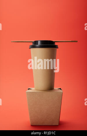 arranged noodle box, paper cup of coffee with chopsticks on red, minimalistic concept Stock Photo