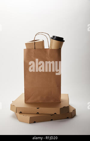 pizza boxes and food delivery paper bag with disposable coffee cup and wok box on white Stock Photo