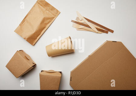 flat lay of disposable knives with forks, paper coffee cup and food boxes on white surface Stock Photo