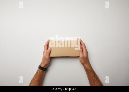 cropped image of man holding delivery food box on white surface Stock Photo