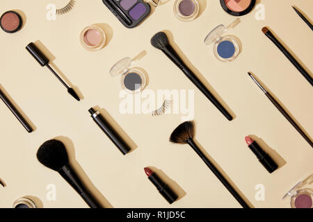 top view of composition of different cosmetics lying on beige surface Stock Photo