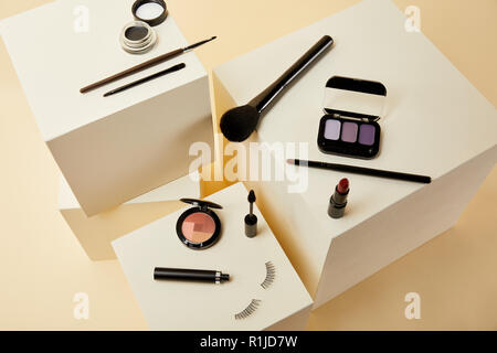 high angle view of various makeup accessories on beige cubes Stock Photo