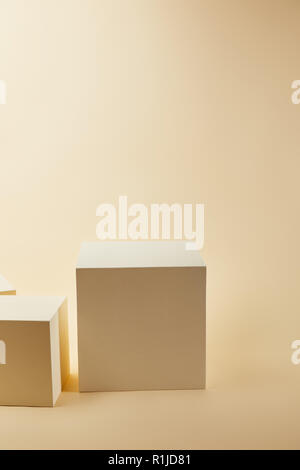 cubes in various sizes on beige surface Stock Photo