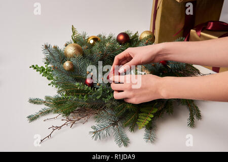 cropped image of woman decorating christmas fir wreath with toys isolated on white Stock Photo