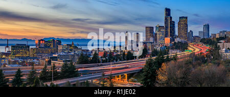 Panorama of Seattle downtown skyline beyond the I-5 I-90 freeway interchange at sunset with long exposure traffic trail lights from Dr. Jose Rizal or  Stock Photo