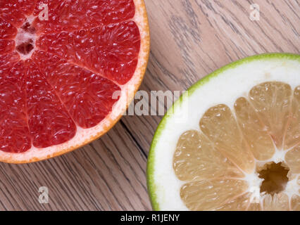 Green Sweetie or Pomelit and Red Grapefruit on wooden background. Top view. Stock Photo