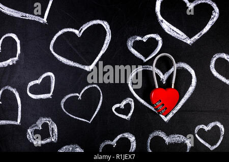 drawn hearts on a chalkboard with red butterflies, concept of love under lock and key Stock Photo