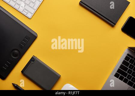 top view of various wireless gadgets on yellow surface Stock Photo