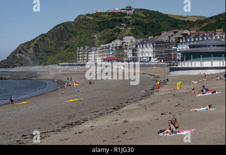 UK Weather: Aberystwyth, Ceredigion, West Wales Monday 18th July 2016. Holiday makers and locals alike take advantage of the early morning Sun to walk Stock Photo