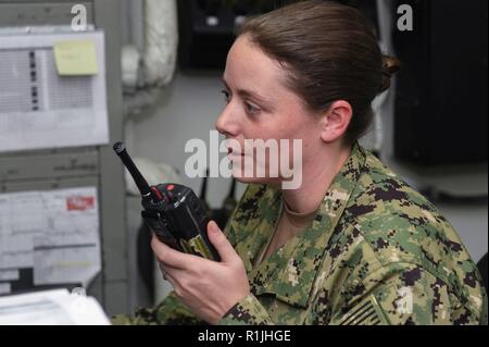 NORWEGIAN SEA (Oct. 20, 2018) Master-at-Arms 1st Class Katie Maguire communicates with on-shift personnel in the security dispatch office aboard the Nimitz-class aircraft carrier USS Harry S. Truman (CVN 75). Currently operating in the U.S. Sixth Fleet area of operations, Harry S. Truman will continue to foster cooperation with regional allies and partners, strengthen regional stability, and remain vigilant, agile and dynamic. Stock Photo