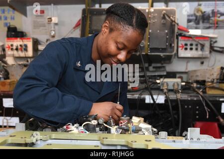 NORWEGIAN SEA (Oct. 20, 2018) Aviation Ordnanceman 3rd Class Anae Gaddy performs maintenance on a bomb rack in the aviation ordnance shop aboard the Nimitz-class aircraft carrier USS Harry S. Truman (CVN 75). Currently operating in the U.S. Sixth Fleet area of operations, Harry S. Truman will continue to foster cooperation with regional allies and partners, strengthen regional stability, and remain vigilant, agile and dynamic. Stock Photo