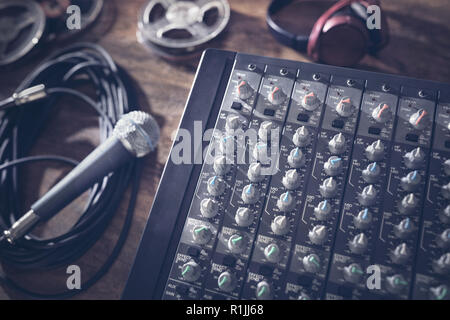 Sound recording studio mixer desk with microphone, headphones and reel tape Stock Photo