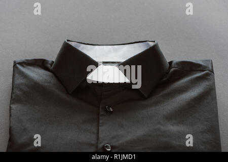 close-up shot of clerical shirt with white collar on grey surface Stock Photo