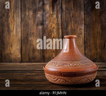 Moroccan tagine (cooking vessel) on a wooden table. Copy space Stock Photo