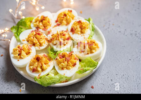 Healthy Deviled Eggs as an Appetizer with Bacon Stock Photo
