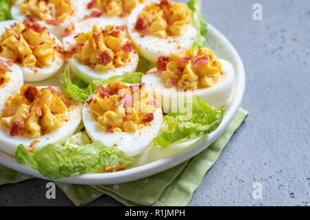 Healthy Deviled Eggs as an Appetizer with Bacon Stock Photo