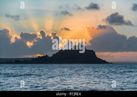 Longrock, Cornwall, UK. 13th November 2018. UK Weather. Rays from the rising sun coming up behind St Michaels Mount at Marazion. Credit: Simon Maycock/Alamy Live News Stock Photo