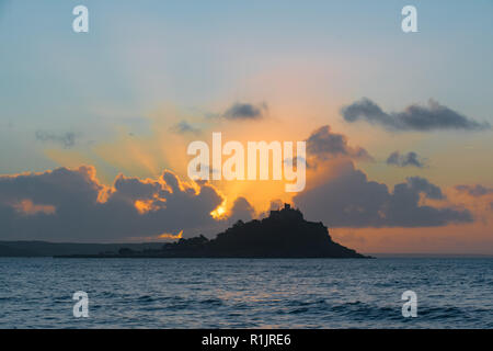 Longrock, Cornwall, UK. 13th November 2018. UK Weather. Rays from the rising sun coming up behind St Michaels Mount at Marazion. Credit: Simon Maycock/Alamy Live News Stock Photo