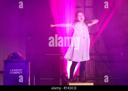 Covent Garden, London, UK, 13th Nov 2018. The young title role performer from Matilda. Paloma Faith switches on the Covent Garden Christmas lights in the iconic Piazza, while The Kingdom Choir and the company of RSC’s Matilda The Musical entertained the crowd. Covent Garden gets a sprinkling of November snow with lots of (fake) snow coming down on hundreds of spectators who have turned up. Credit: Imageplotter News and Sports/Alamy Live News Stock Photo