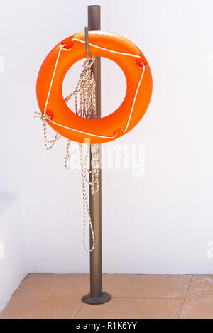 Save Download Preview One orange lifebuoy hanging on a pole Stock Photo