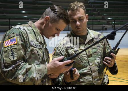 Army Sgt. James Kemper and Sgt. R.C. Samples, support staff with the Florida National Guard's 3-20th Special Forces Group, familiarize CERF-P members with HARRIS radios. The CERF-P will use these radios to coordinate aerial rescues during their recon of areas impacted by Hurricane Michael. Stock Photo