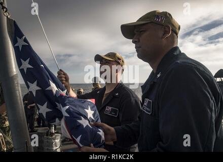 MEDITERRANEAN SEA (Oct. 12, 2018) Fire Controlman 3rd Class Herman Weber, left, and fire Controlman 3rd Class Jesus Carrizoza prepare to raise the American Flag aboard the Arleigh Burke-class guided-missile destroyer USS Carney (DDG 64) Oct. 12, 2018. Carney, forward-deployed to Rota, Spain, is on its fifth patrol in the U.S. 6th Fleet area of operations in support of regional allies and partners as well as U.S. national security interests in Europe and Africa. Stock Photo