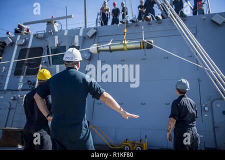 PACIFIC OCEAN (Oct. 14, 2018) Sailors supervise the lowering of a MK46 torpedo as it is relocated from the surface-vessel torpedo tubes to the torpedo magazine aboard the Arleigh-Burke class guided-missile destroyer USS Michael Murphy (DDG 112). Michael Murphy is underway conducting routine operations in the 3rd Fleet area of operations. Stock Photo