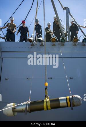 PACIFIC OCEAN (Oct. 14, 2018) Sailors lower a MK46 torpedo as it is relocated from the surface-vessel torpedo tubes to the torpedo magazine aboard the Arleigh-Burke class guided-missile destroyer USS Michael Murphy (DDG 112). Michael Murphy is underway conducting routine operations in the 3rd Fleet area of operations. Stock Photo